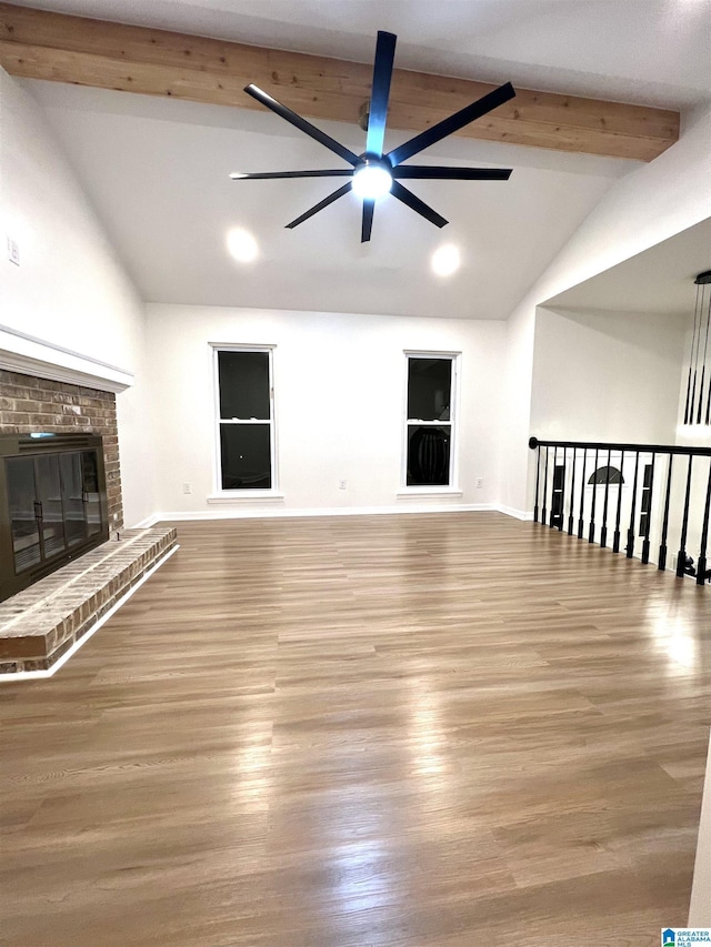 unfurnished living room featuring vaulted ceiling with beams, ceiling fan, light hardwood / wood-style flooring, and a brick fireplace