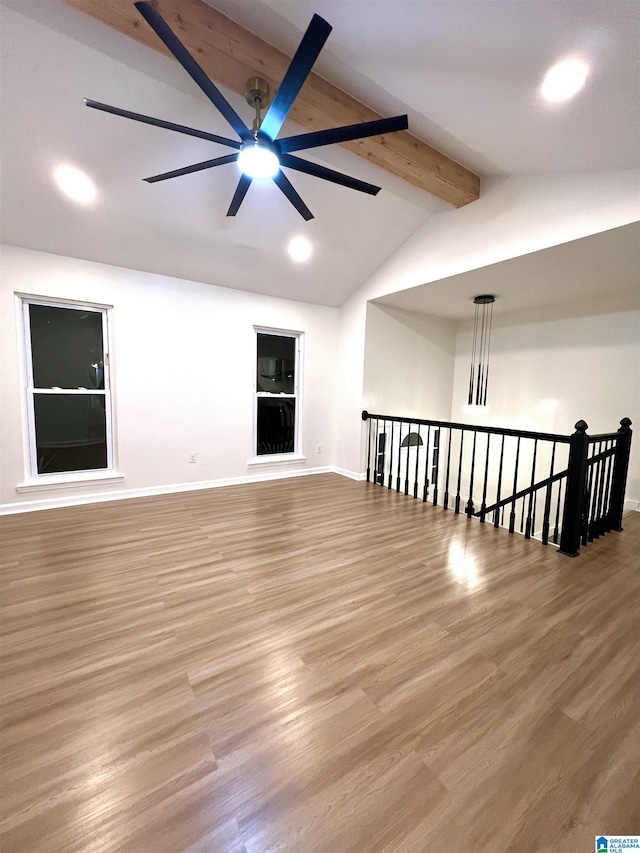 empty room with ceiling fan, lofted ceiling with beams, and light hardwood / wood-style floors