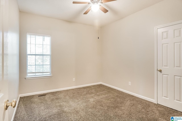 carpeted spare room featuring ceiling fan