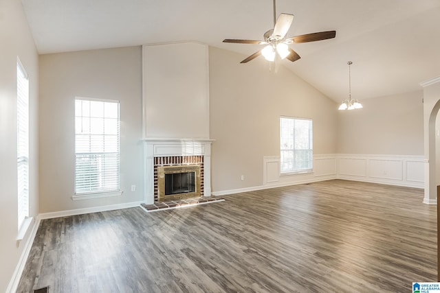 unfurnished living room with plenty of natural light, dark hardwood / wood-style floors, and a brick fireplace