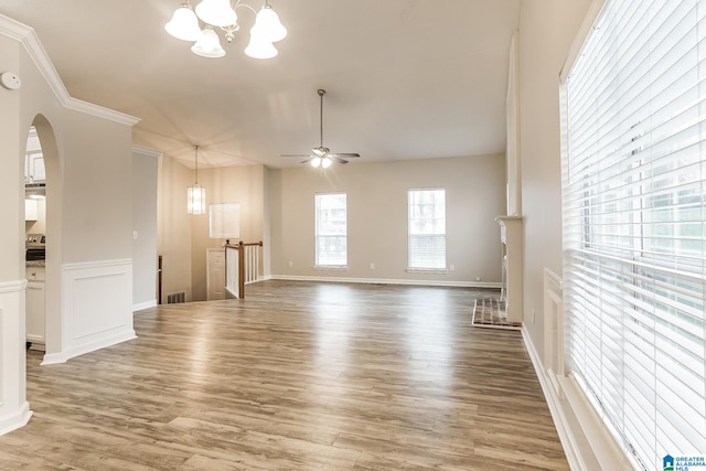 spare room with ceiling fan with notable chandelier, wood-type flooring, and ornamental molding