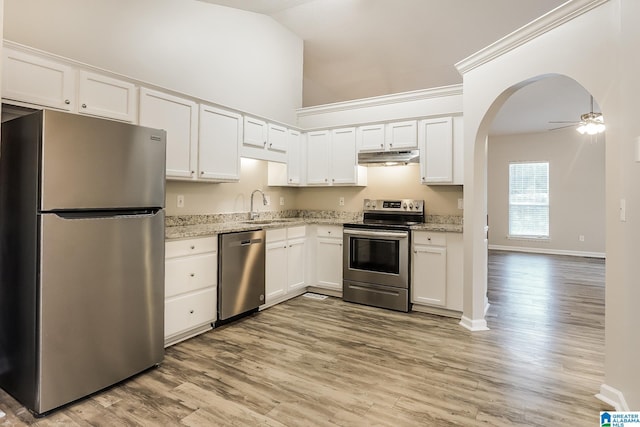 kitchen with light stone counters, stainless steel appliances, sink, light hardwood / wood-style flooring, and white cabinetry