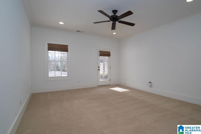 spare room featuring ceiling fan, ornamental molding, and light carpet