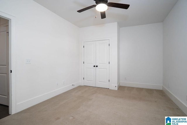 unfurnished bedroom with ceiling fan, light carpet, and a closet