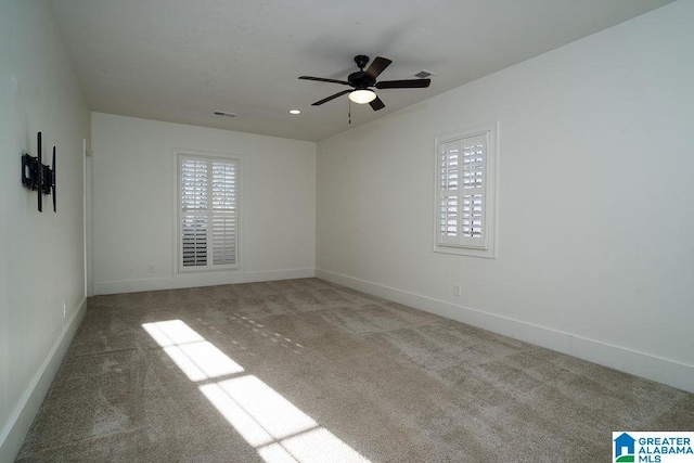 carpeted empty room with a wealth of natural light and ceiling fan