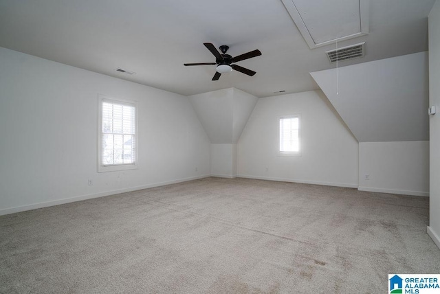 bonus room featuring light carpet, vaulted ceiling, ceiling fan, and a healthy amount of sunlight