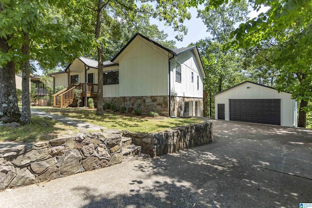 view of front facade featuring a garage, an outdoor structure, and a wooden deck