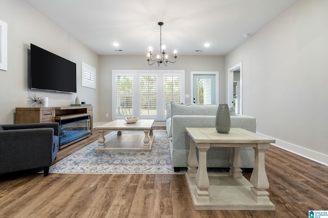 living room featuring an inviting chandelier and hardwood / wood-style flooring