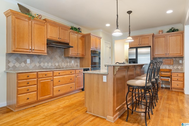 kitchen featuring light stone counters, a kitchen island, and ornamental molding