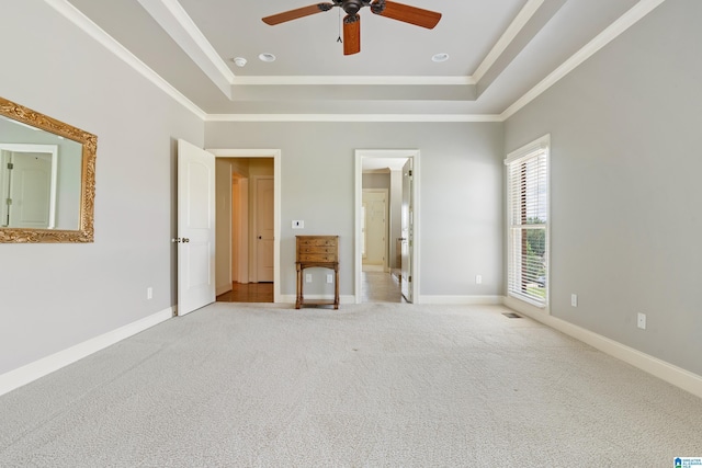 unfurnished bedroom featuring a raised ceiling, ceiling fan, crown molding, and light colored carpet