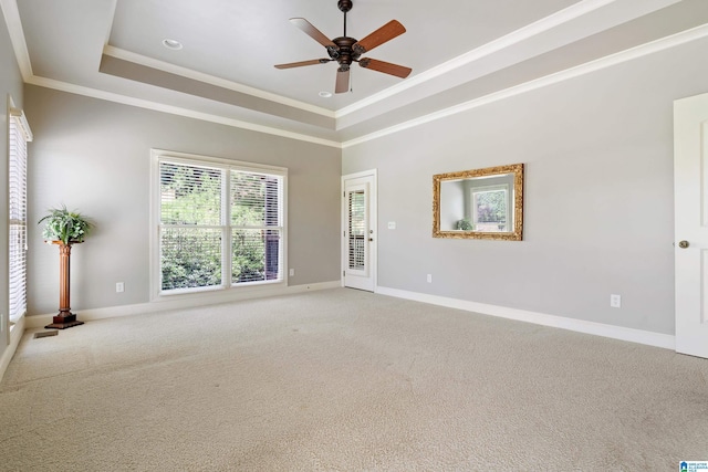 spare room featuring carpet flooring, ceiling fan, crown molding, and a tray ceiling