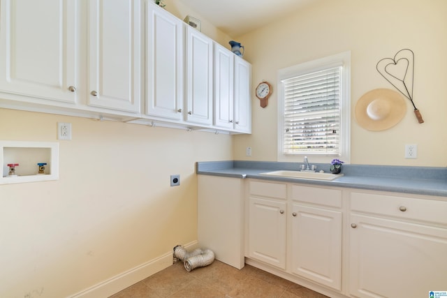 clothes washing area featuring electric dryer hookup, cabinets, sink, washer hookup, and light tile patterned flooring