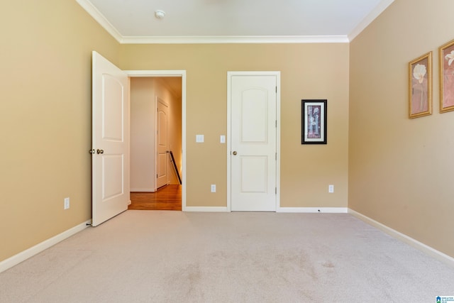 unfurnished bedroom with light colored carpet and crown molding