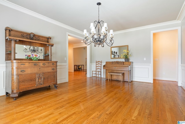 dining space with hardwood / wood-style flooring, an inviting chandelier, and crown molding