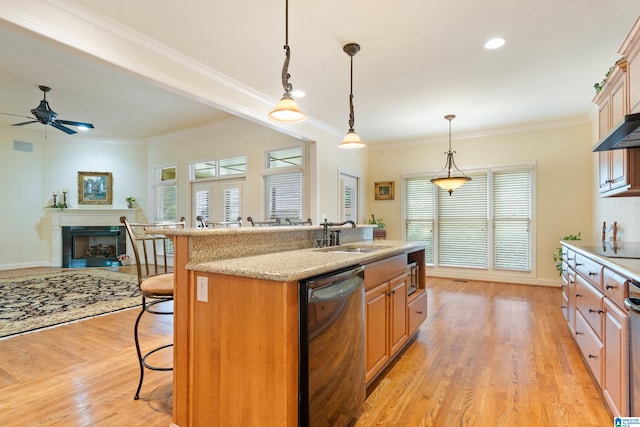 kitchen featuring a kitchen breakfast bar, sink, decorative light fixtures, a center island with sink, and dishwasher