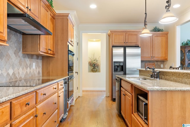 kitchen featuring light stone counters, ornamental molding, hanging light fixtures, and light hardwood / wood-style flooring