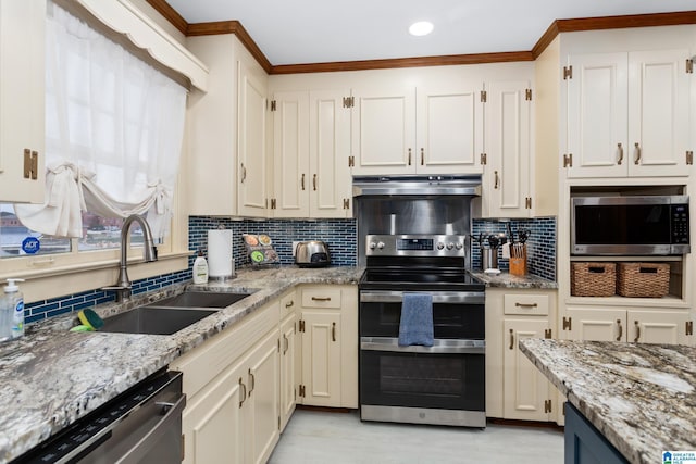 kitchen with decorative backsplash, light stone counters, sink, and appliances with stainless steel finishes