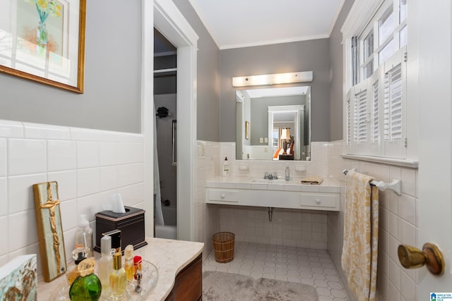 bathroom with vanity, ornamental molding, and tile walls