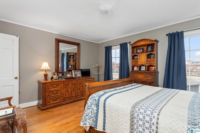 bedroom with crown molding and light hardwood / wood-style flooring