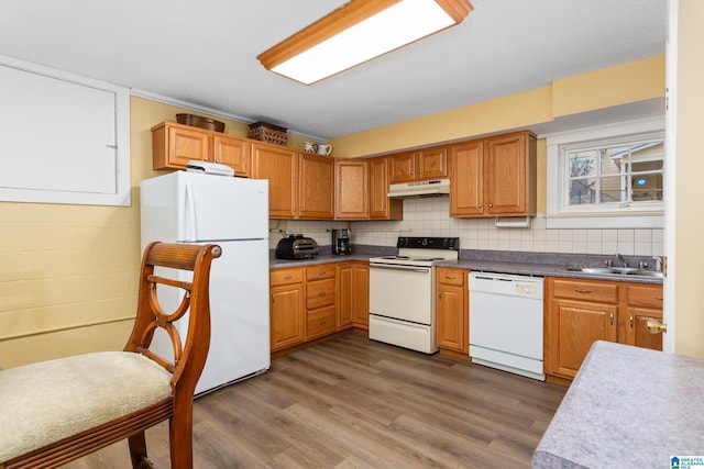 kitchen with backsplash, dark hardwood / wood-style flooring, sink, and white appliances