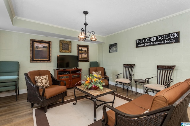 living room with ornamental molding, a chandelier, and wood-type flooring