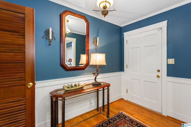 entryway with light wood-type flooring and crown molding