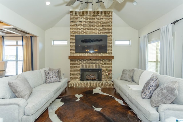 living room featuring a fireplace, dark hardwood / wood-style flooring, vaulted ceiling, and ceiling fan