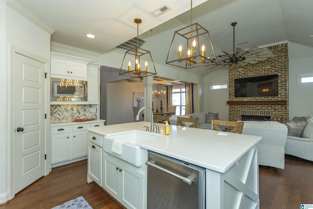 kitchen with white cabinets, a fireplace, an island with sink, and stainless steel appliances