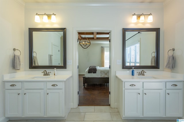 bathroom with tile patterned flooring, vanity, a notable chandelier, and ornamental molding