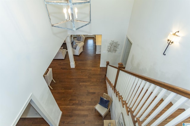 staircase with hardwood / wood-style flooring and a notable chandelier