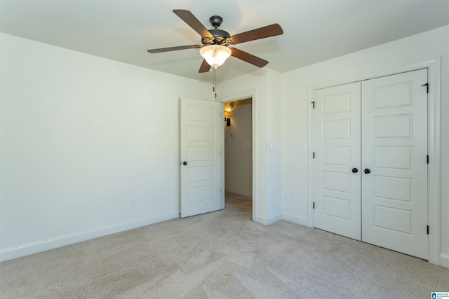 unfurnished bedroom with ceiling fan, light carpet, and a closet