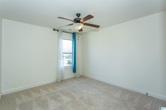 empty room featuring light colored carpet and ceiling fan