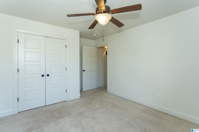 unfurnished bedroom featuring light carpet, a closet, and ceiling fan