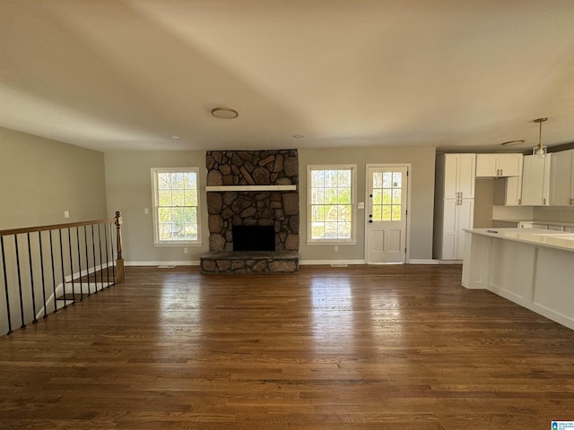 unfurnished living room with dark hardwood / wood-style flooring and a fireplace