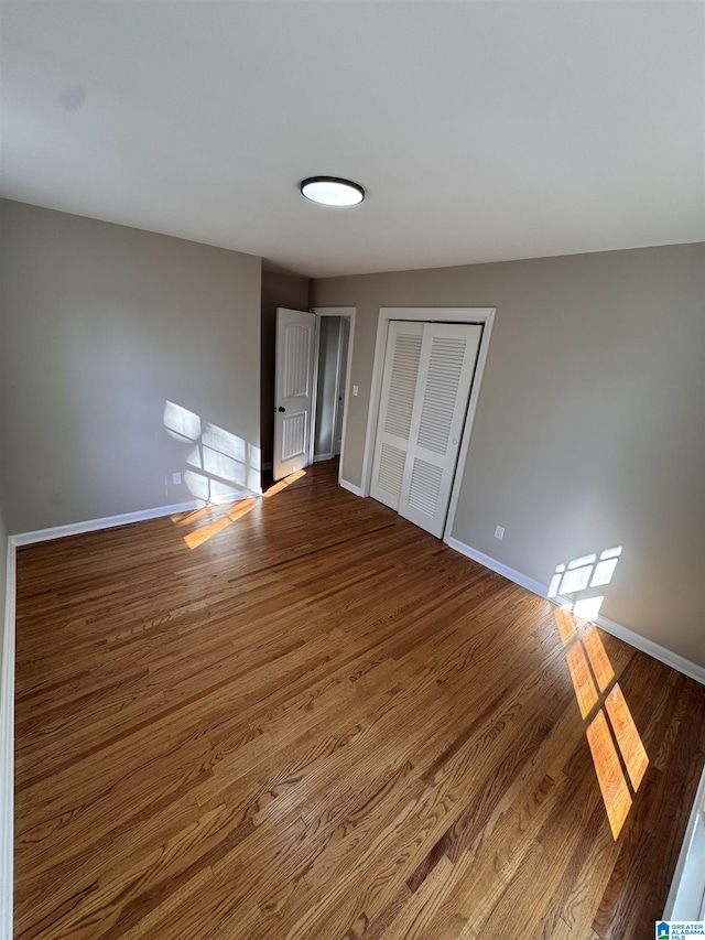 unfurnished bedroom featuring hardwood / wood-style floors and a closet