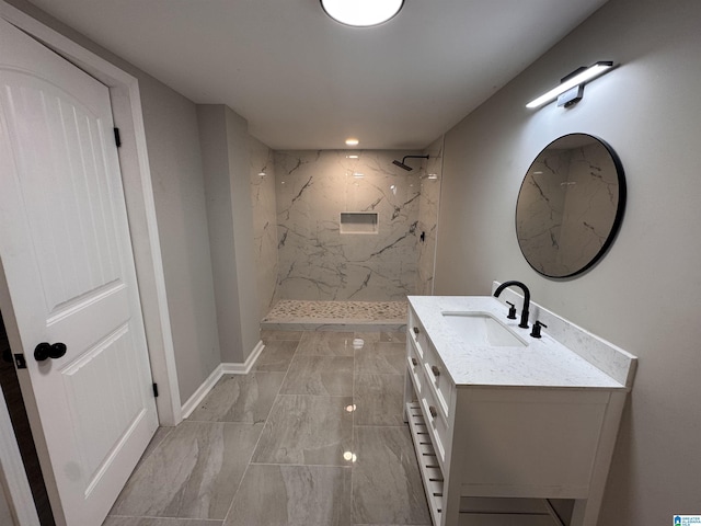 bathroom with tiled shower and vanity