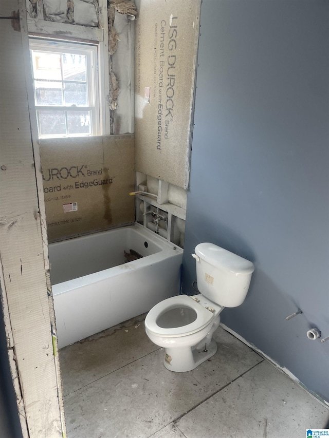 bathroom with toilet and a tub to relax in