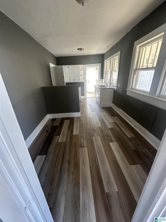 corridor with sink and dark wood-type flooring