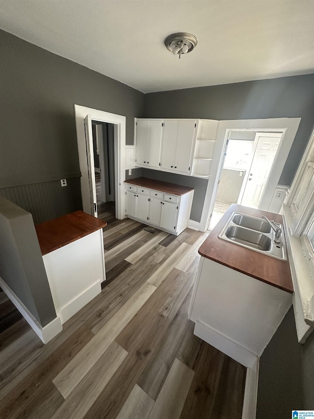 kitchen with white cabinetry, sink, and light wood-type flooring