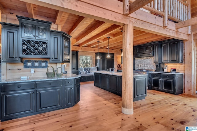 kitchen with decorative backsplash, light stone counters, wood ceiling, decorative light fixtures, and light hardwood / wood-style floors