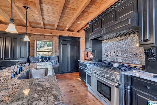 kitchen with custom range hood, dark stone countertops, sink, and range with two ovens