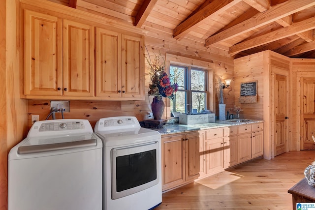 laundry area with cabinets, washing machine and dryer, light hardwood / wood-style flooring, wooden walls, and wood ceiling