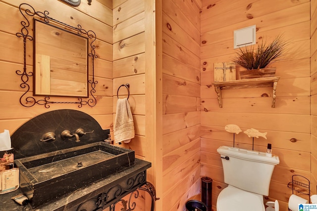 bathroom with wood walls and toilet