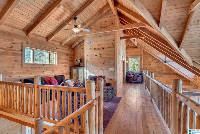 bonus room with hardwood / wood-style floors, wooden walls, vaulted ceiling with beams, plenty of natural light, and wood ceiling