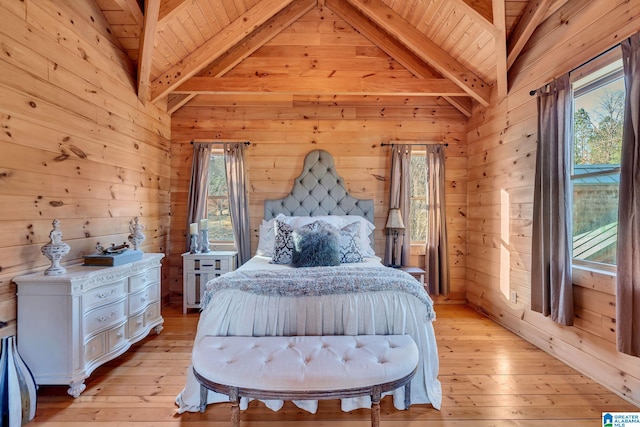 bedroom featuring wood walls, light hardwood / wood-style floors, and beamed ceiling