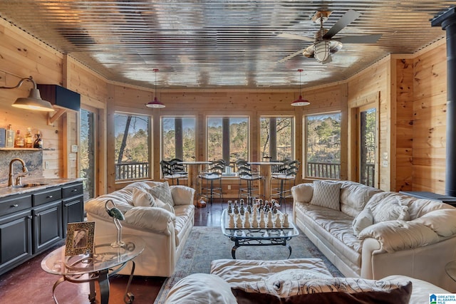 living room featuring wooden walls, wet bar, ceiling fan, and wooden ceiling