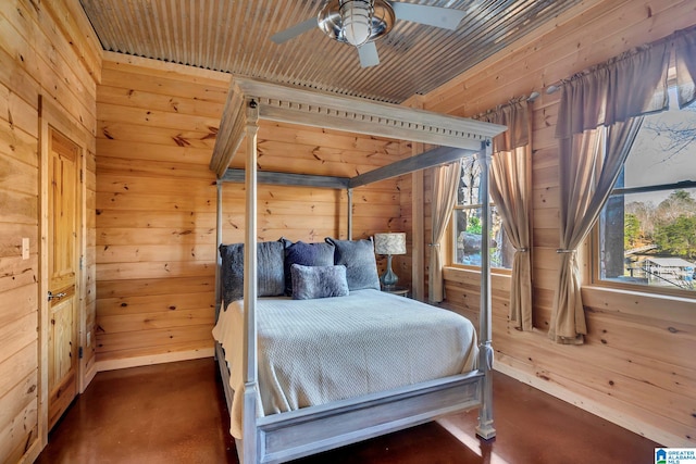 bedroom with ceiling fan, wood walls, and wooden ceiling