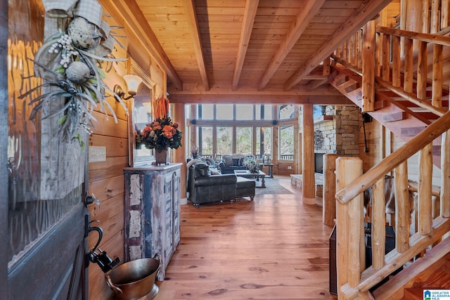 unfurnished living room with wood walls, beam ceiling, wooden ceiling, and hardwood / wood-style flooring