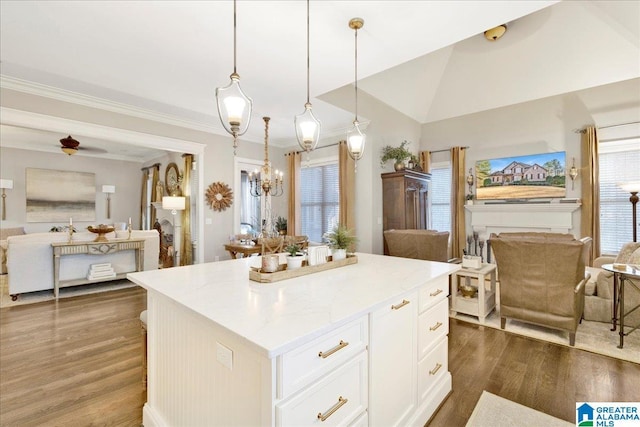 kitchen with dark wood-type flooring, white cabinets, a center island, hanging light fixtures, and lofted ceiling