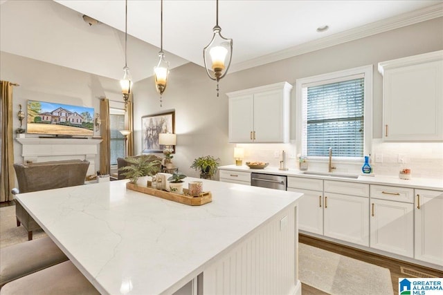 kitchen with sink, white cabinets, decorative light fixtures, and a kitchen island